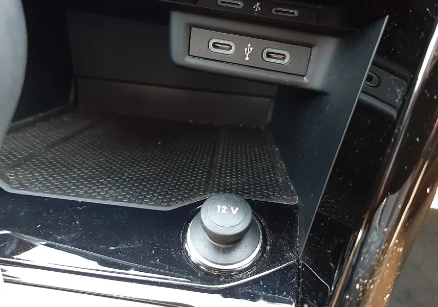 Détail de la console centrale noire du Volkswagen T-Roc 2024, avec prises USB-C et prise 12V visible.