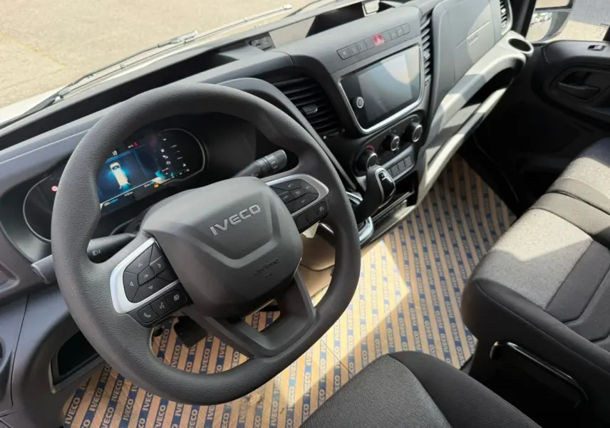 Vue intérieure du poste de conduite de l’Iveco Daily 2026, volant multifonction et tableau de bord moderne en gris foncé.