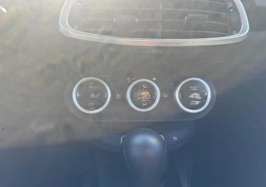Gros plan sur la console centrale du Fiat 500X bleu MY23, montrant les commandes de climatisation manuelle et le levier de boîte automatique.