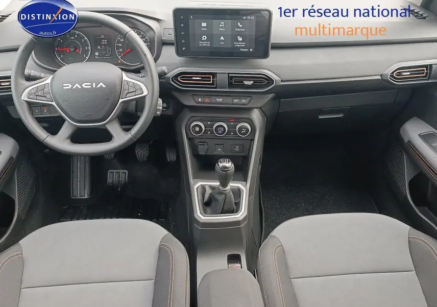 Intérieur noir de la Dacia Sandero 2025 vue de face, volant multifonction et écran tactile central visible.