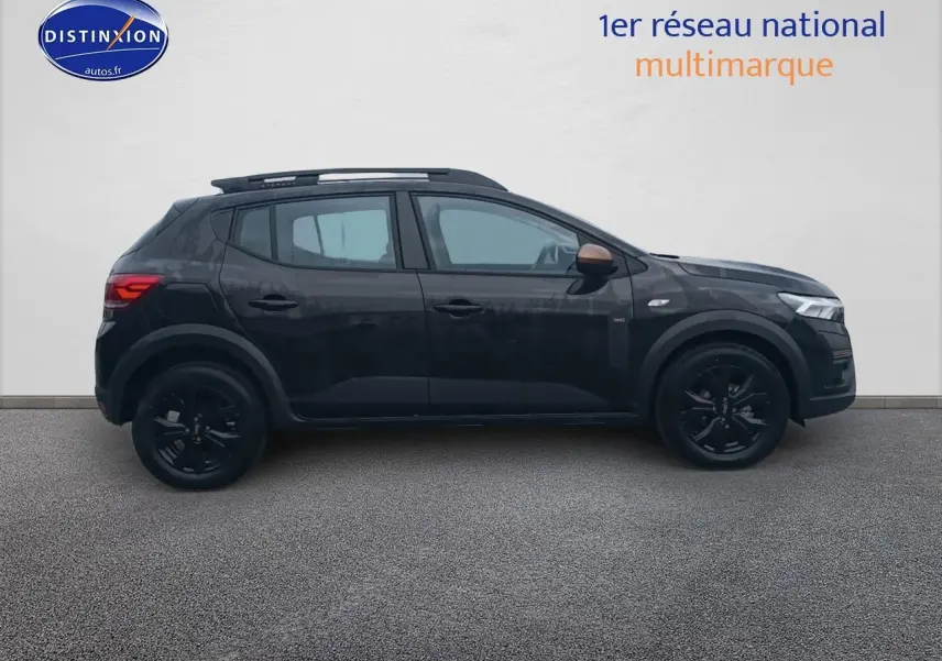 Profil côté gauche d'une Dacia Sandero Stepway noire 2025 avec jantes noires et barres de toit visibles.