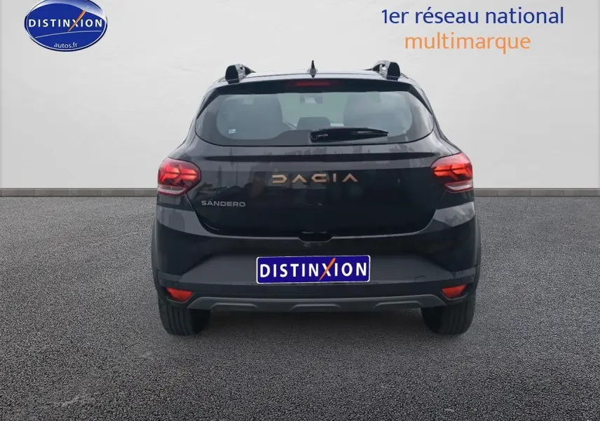 Vue arrière d'une Dacia Sandero noire 2025 avec feux rouges et logo DACIA en lettres dorées.