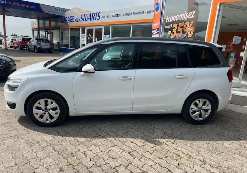 Profil côté gauche d'un Citroën Grand C4 Picasso blanc, avec vitres surteintées et jantes alliage 16 pouces visibles.