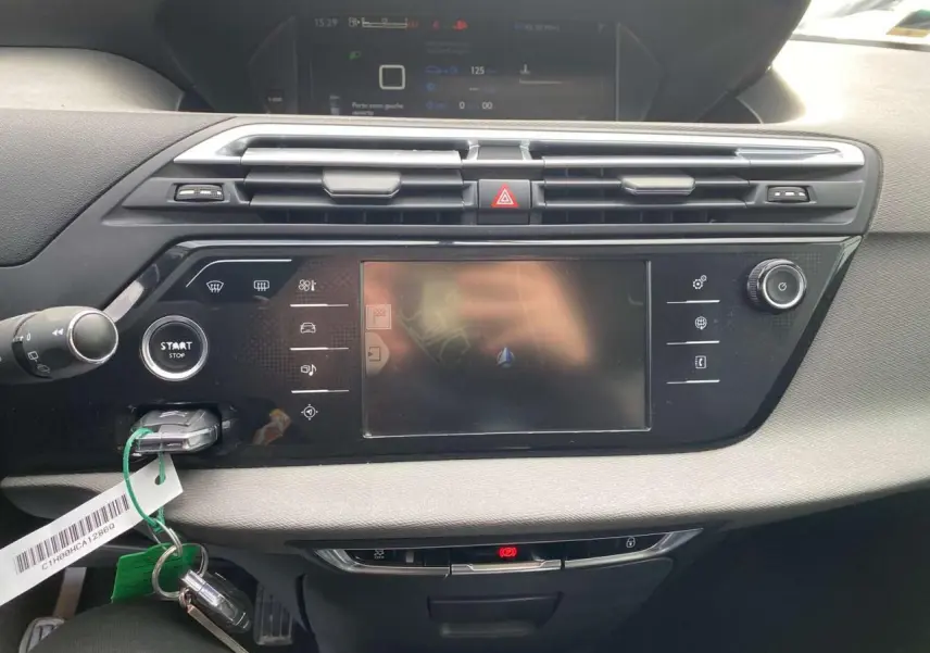 Tableau de bord noir et gris du Citroën Grand C4 Picasso 2015, avec écran tactile central et bouton start/stop visible.