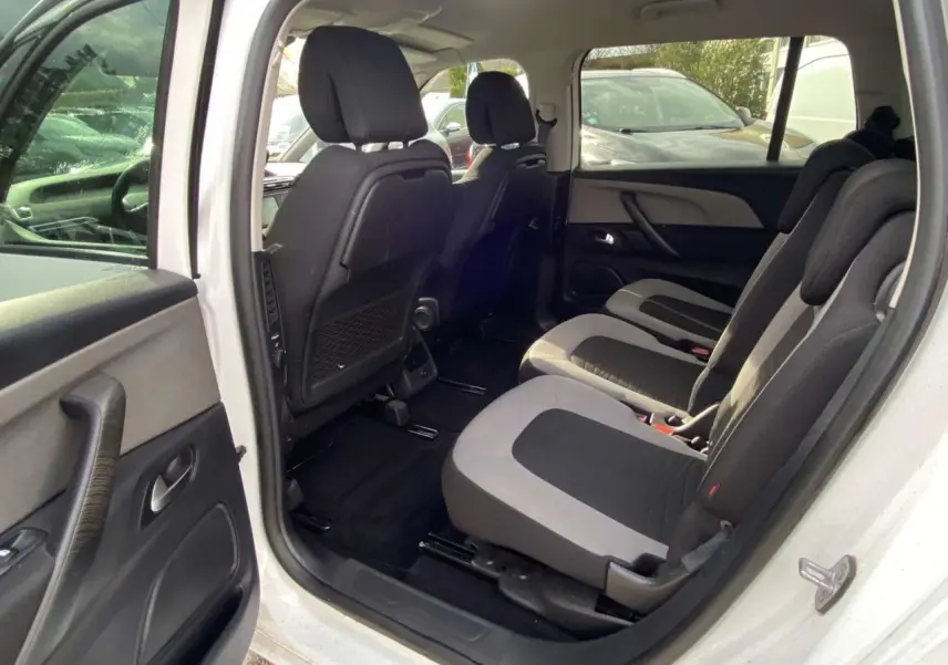 Vue intérieure côté droit du Citroën Grand C4 Picasso blanc, montrant les sièges de la deuxième rangée en tissu bicolore.