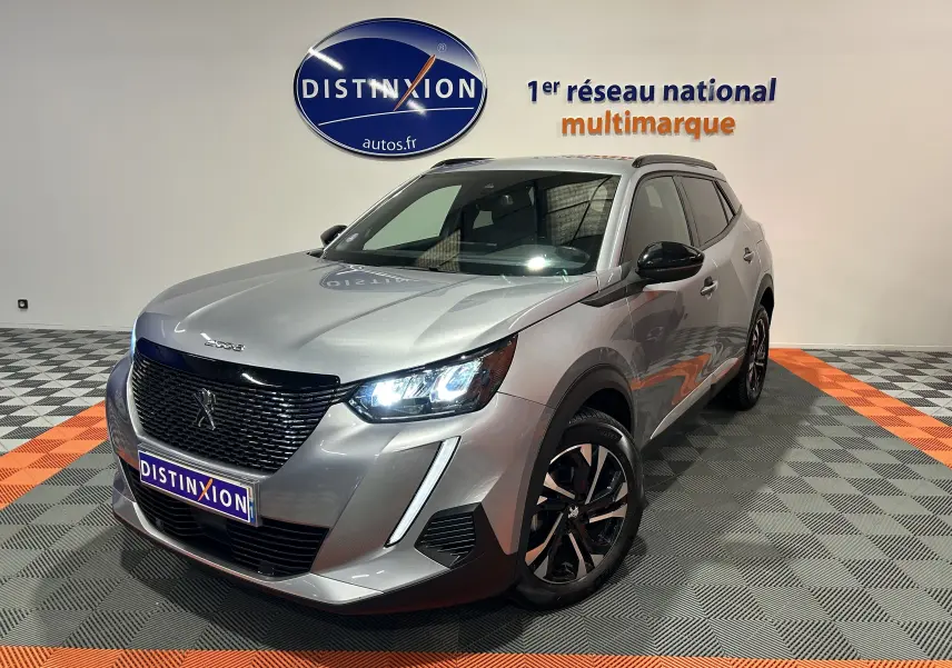 Peugeot 2008 gris Artense vue 3/4 avant droit avec phares LED allumés et jantes noires bicolores.