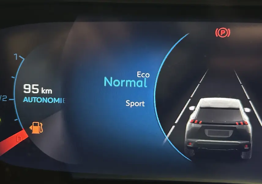 Affichage numérique du tableau de bord montrant l'autonomie, mode de conduite Normal, et silhouette arrière du Peugeot 2008 gris Artense.