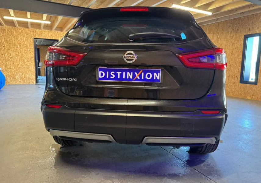 Vue arrière d'un Nissan Qashqai noir 2017 dans un garage avec feux arrière et logo visibles.