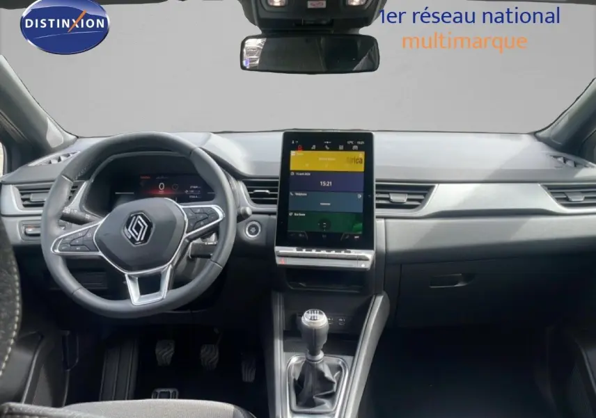 Vue intérieure frontale du Renault Captur 2025, tableau de bord noir avec écran tactile vertical et levier de vitesses manuel.