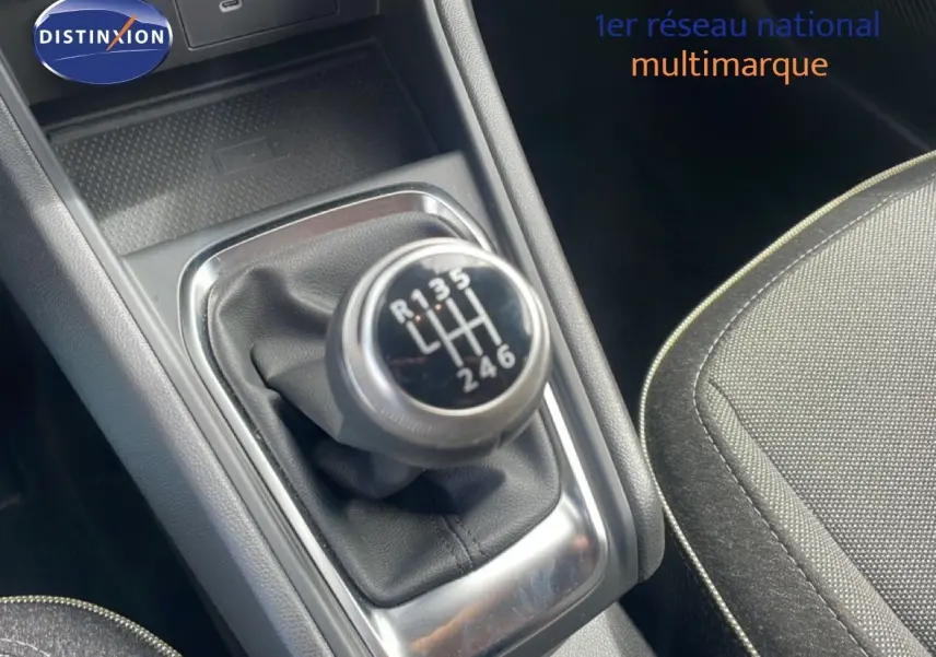 Gros plan sur le levier de vitesse manuel du Renault Captur 2025, intérieur tissu gris et console noire.