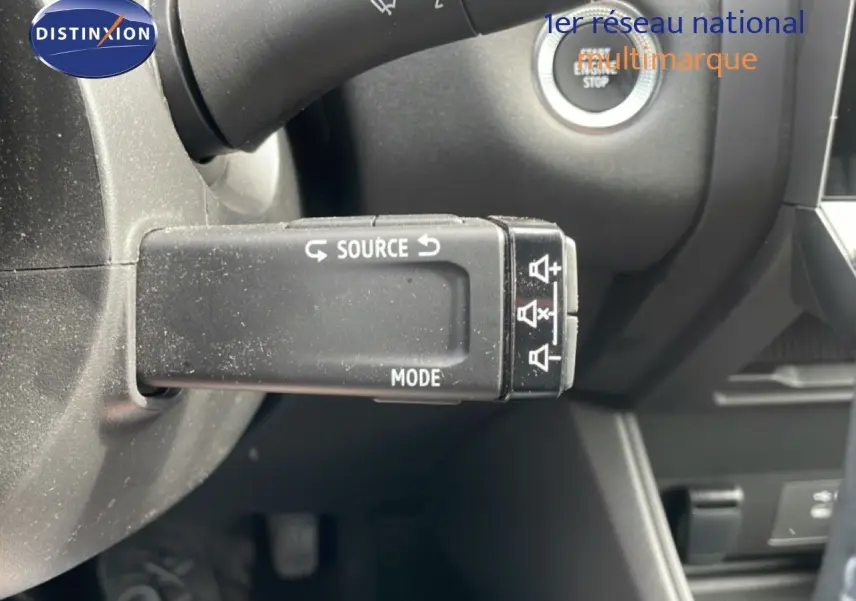 Gros plan sur la commande multimédia au volant du Renault Captur gris cassiopée métal avec toit noir, intérieur noir.