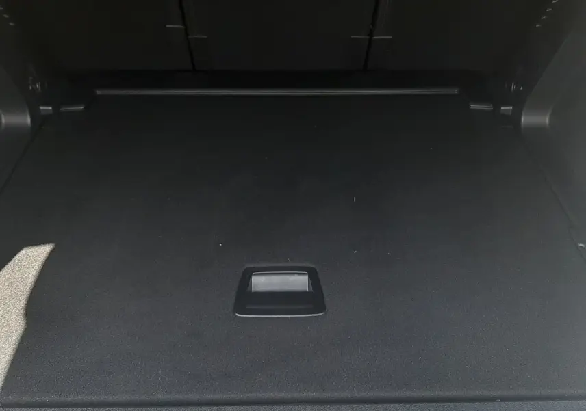 Coffre noir spacieux du Citroën C5 Aircross Ph.2 Hybrid 145ch vu de face, avec poignée centrale intégrée.