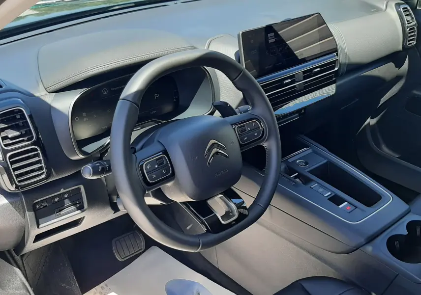 Vue intérieure côté conducteur du Citroën C5 Aircross noir, avec tableau de bord numérique et écran tactile central.