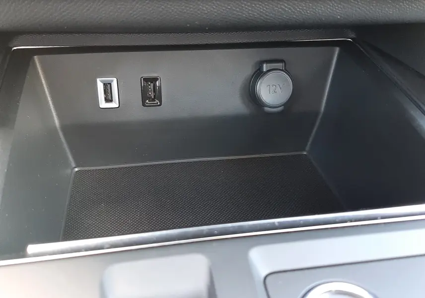 Vue rapprochée de la console centrale noire du Citroën C5 Aircross avec prises USB et prise 12V visibles.