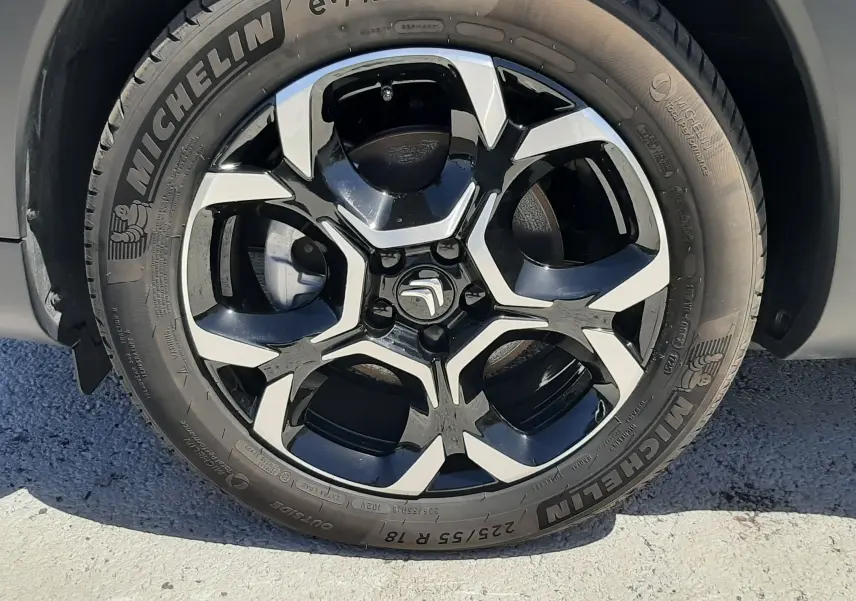 Gros plan sur la roue avant droite du Citroën C5 Aircross 2025 noir Perla Nera avec jante alliage bicolore et pneu Michelin e-Primacy.