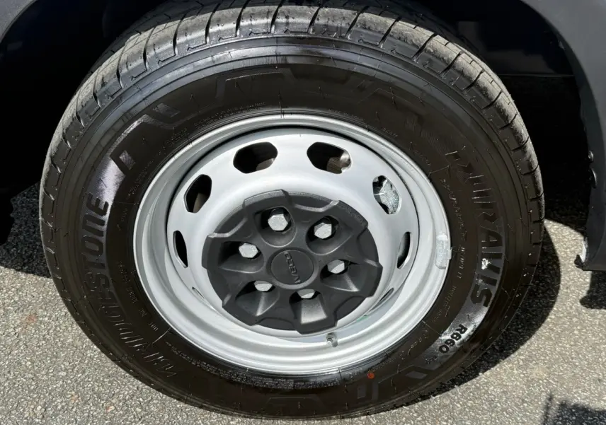 Gros plan sur la roue avant droite du fourgon Iveco Daily blanc 2026, pneu Bridgestone et jante acier grise.
