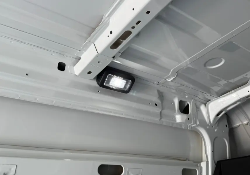 Vue intérieure du plafond blanc du fourgon Iveco Daily 2.3 35S16 V12 avec éclairage LED intégré.