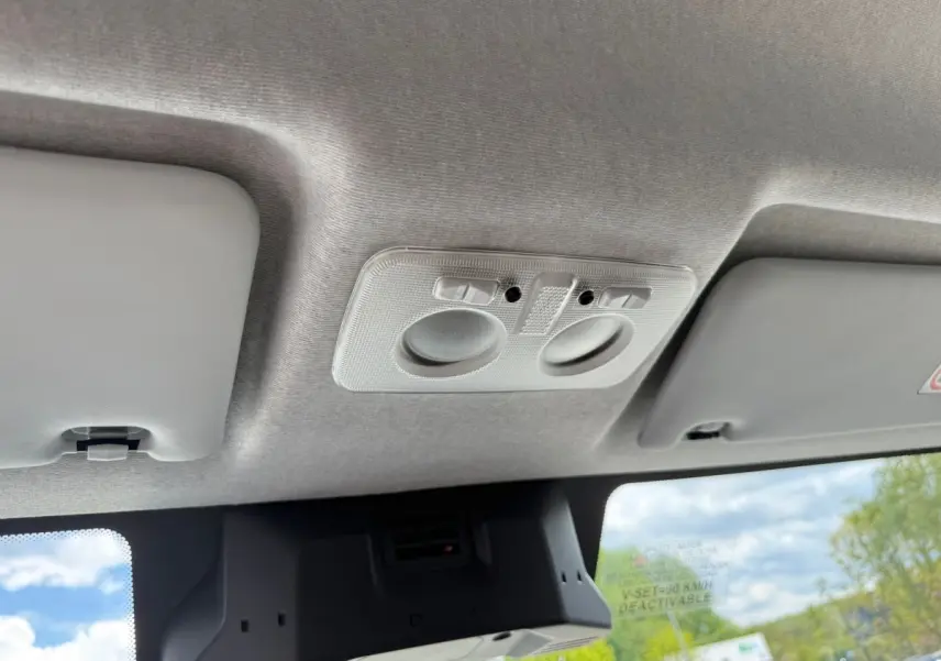 Vue intérieure du plafond gris clair de l'Iveco Daily 2.3 blanc, avec éclairages de lecture intégrés.