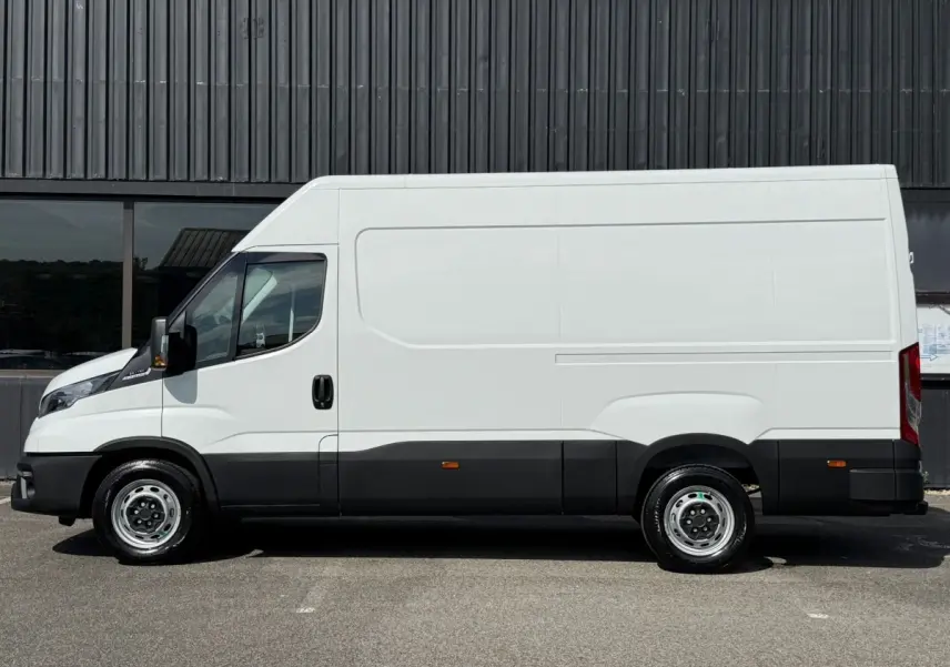Vue latérale droite d’un utilitaire Iveco Daily blanc 2026 avec carrosserie haute et bas de caisse noir.