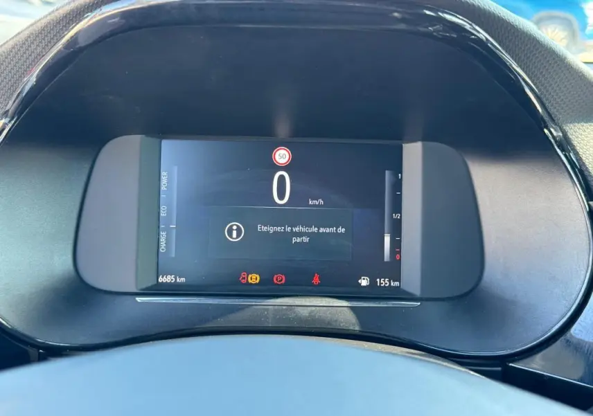 Vue rapprochée du tableau de bord numérique de l’Opel Corsa rouge 2025, affichant 0 km/h et alertes actives.
