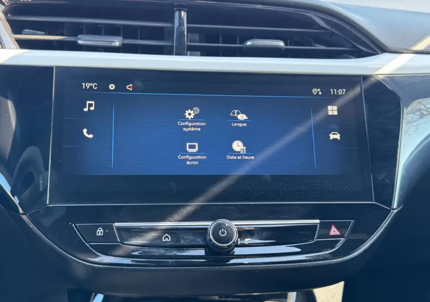 Écran tactile central de l’Opel Corsa 2025 affichant les réglages système, avec boutons de commande en dessous.