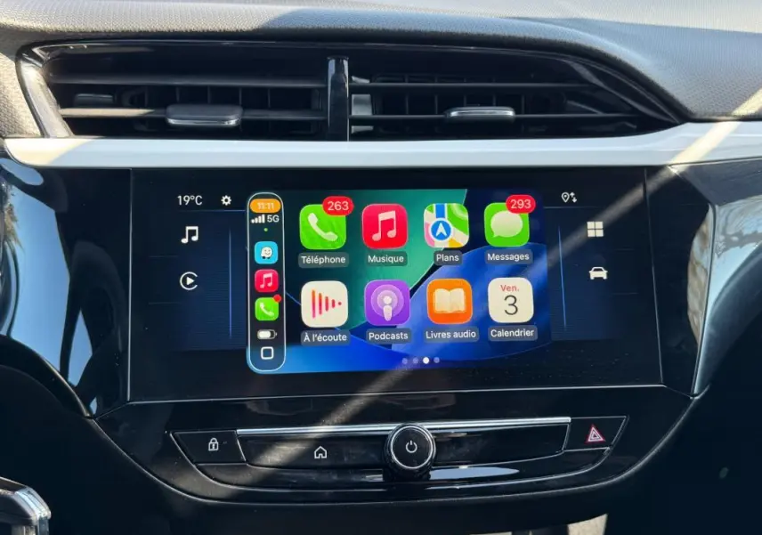 Vue rapprochée de l’écran tactile central de l’Opel Corsa rouge 2025, affichant l’interface Apple CarPlay.