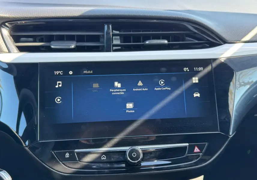 Écran tactile central de l’Opel Corsa rouge 2025, vue frontale du tableau de bord avec interface multimédia affichée.