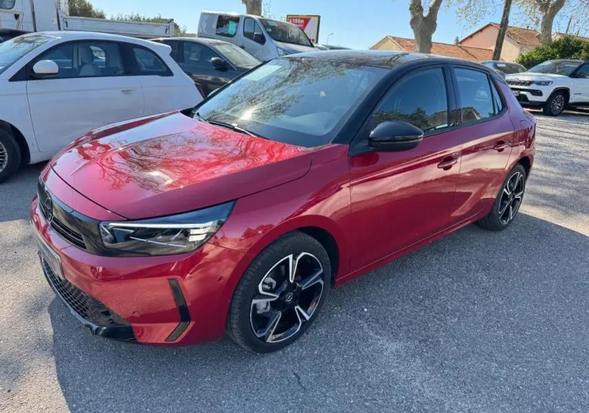 Opel Corsa rouge 2025 vue 3/4 avant droit, avec jantes noires et toit noir contrasté.
