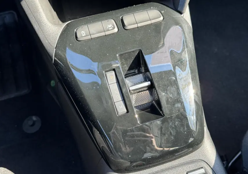 Vue rapprochée de la console centrale noire brillante avec sélecteur de boîte automatique de l’Opel Corsa rouge 2025.