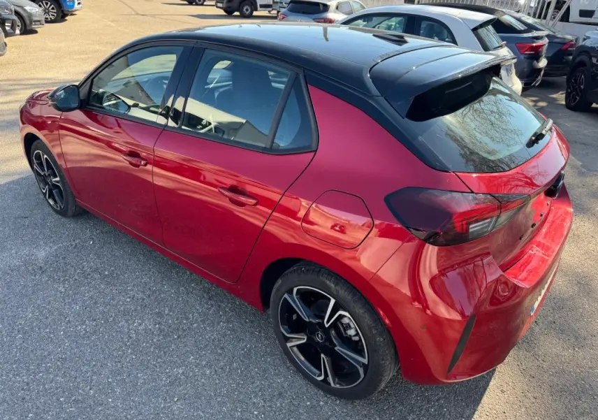 Opel Corsa 2025 rouge vue 3/4 arrière droit, toit noir contrasté et jantes alliage noires distinctives.