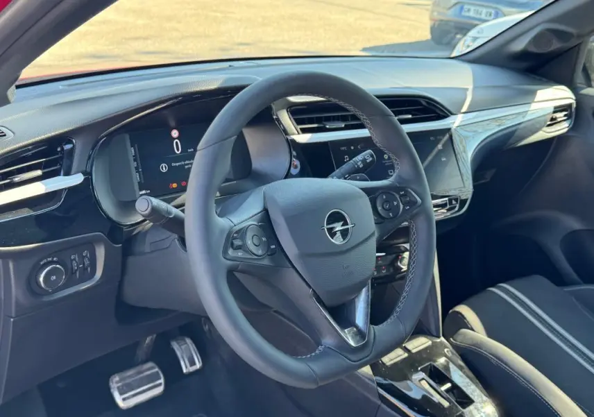Vue intérieure centrée sur le volant Opel de la Corsa 2025, tableau de bord numérique et console centrale moderne visibles.