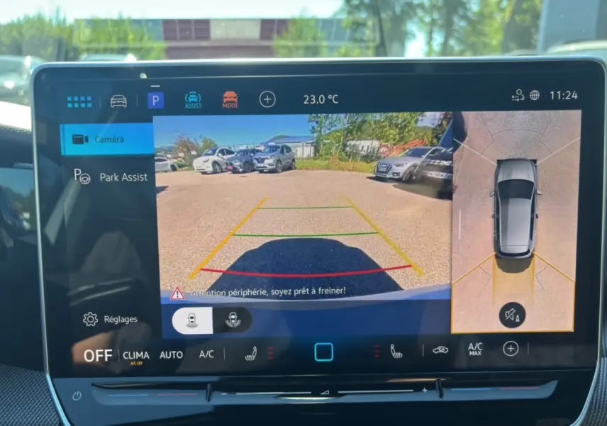Écran tactile intérieur affichant la caméra 360° et l’aide au stationnement d’une Volkswagen Golf blanche.