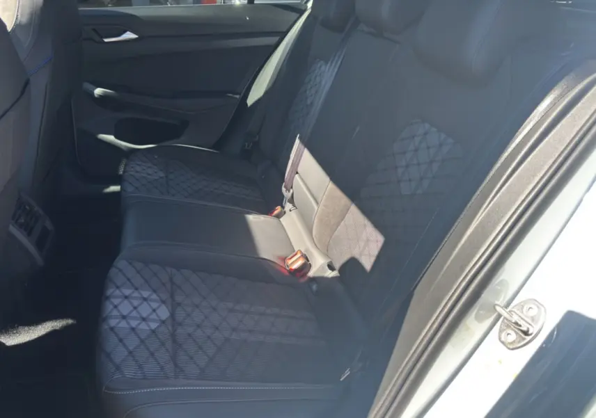 Vue intérieure côté droit sur la banquette arrière en tissu noir à motifs géométriques de la Volkswagen Golf blanc oryx.