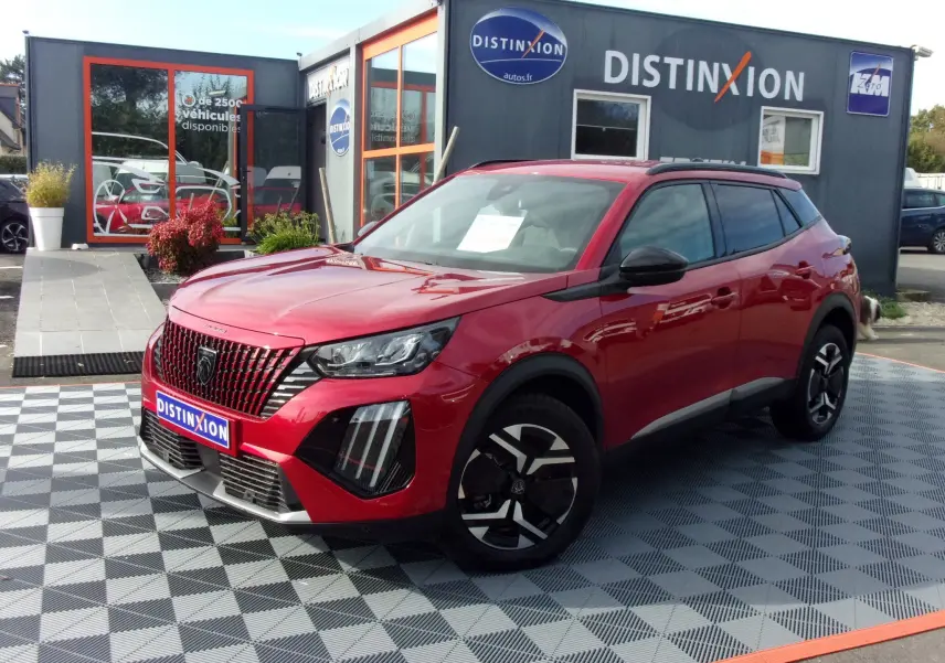 Peugeot 2008 rouge Elixir vue 3/4 avant droit, avec calandre distinctive et jantes noires au design moderne.