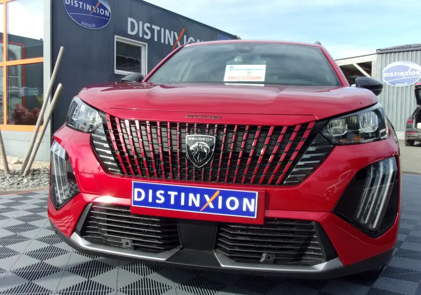 Vue frontale d'un Peugeot 2008 rouge Elixir 2024 avec calandre distinctive et phares LED marqués.