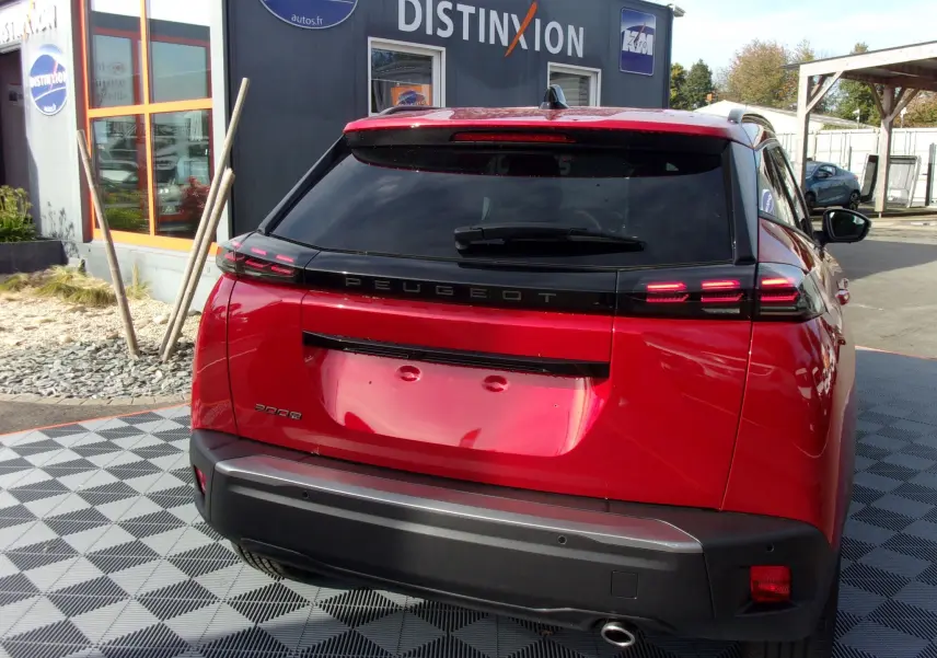 Vue arrière d'un Peugeot 2008 rouge Elixir 2024 avec feux LED distinctifs et lunette arrière teintée.