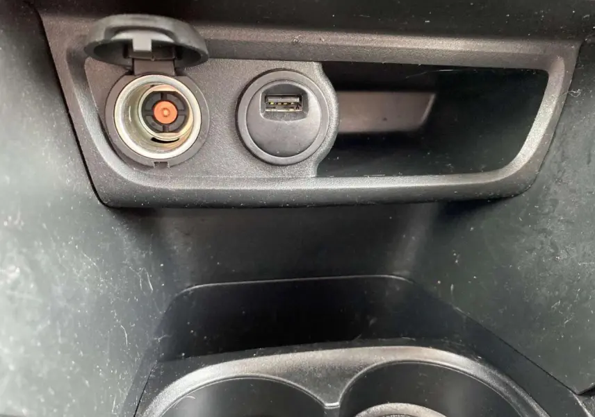 Gros plan sur la prise allume-cigare et port USB dans la console centrale noire du Peugeot 2008 gris platinium.