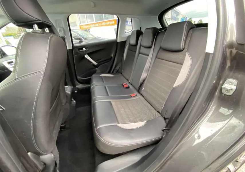 Vue intérieure du siège arrière droit du Peugeot 2008 gris platinium, montrant la banquette en cuir et tissu avec ceintures de sécurité.
