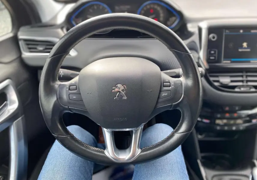 Vue centrée sur le volant cuir Peugeot 2008 2019, avec tableau de bord et écran tactile en arrière-plan.