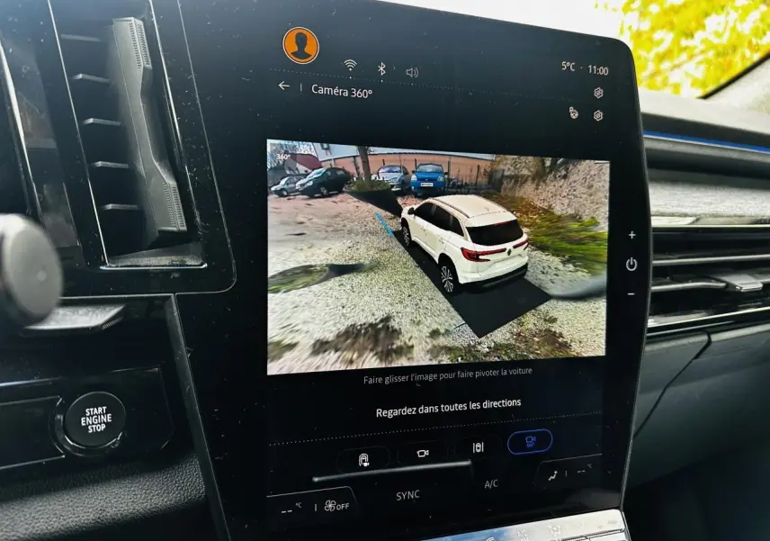 Écran tactile intérieur montrant la vue 360° 3D du Renault Austral blanc en stationnement extérieur.
