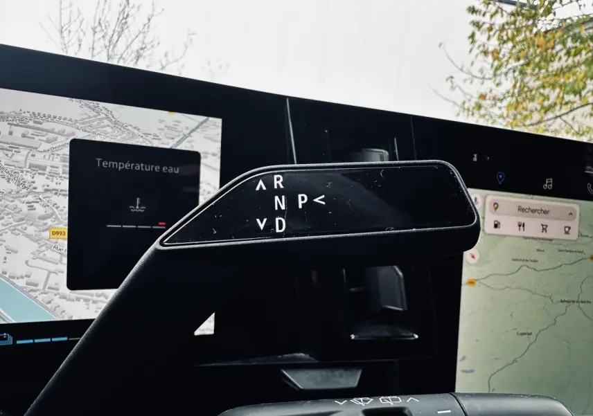 Le levier de boîte automatique noir du Renault Austral 2024, avec affichage des modes de conduite sur fond d'écran multimédia.