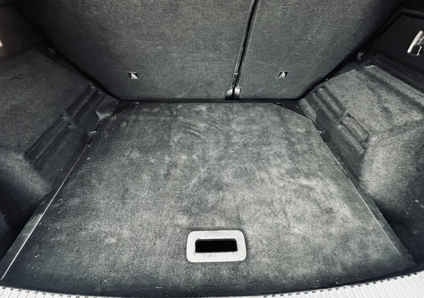 Vue intérieure du coffre du Renault Austral 2024 blanc, montrant la surface de chargement avec tapis noir.