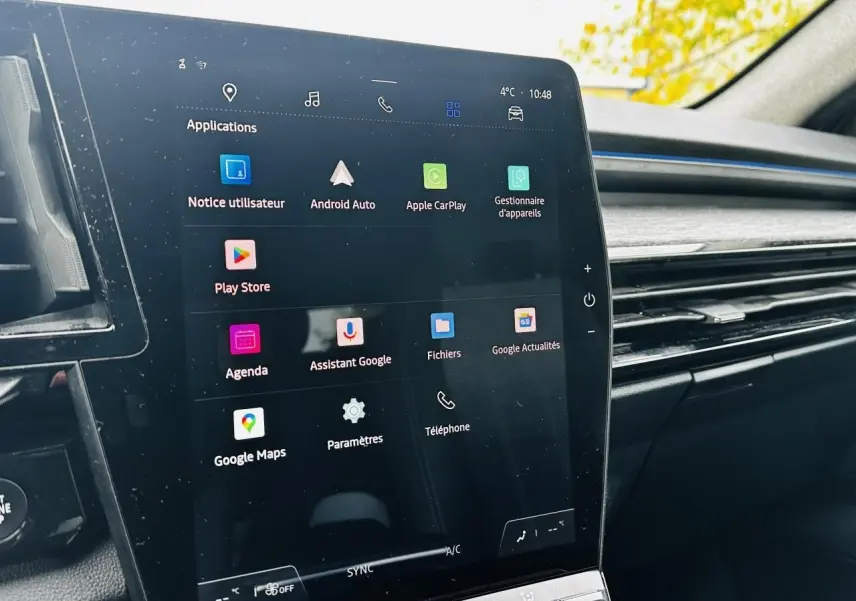 Écran tactile central vertical affichant les applications Google dans l'habitacle du Renault Austral blanc, vue de côté droit.