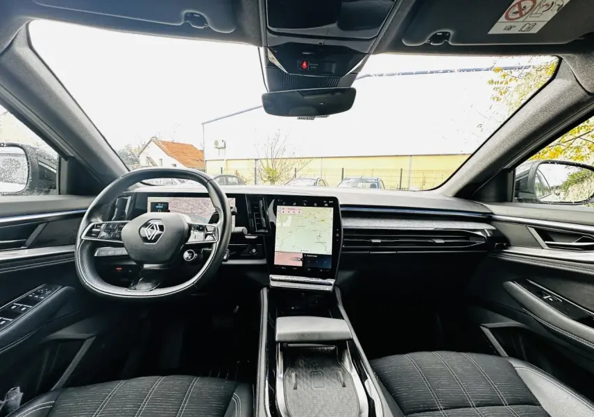 Vue intérieure avant du Renault Austral 2024 avec tableau de bord numérique et écran tactile central vertical.