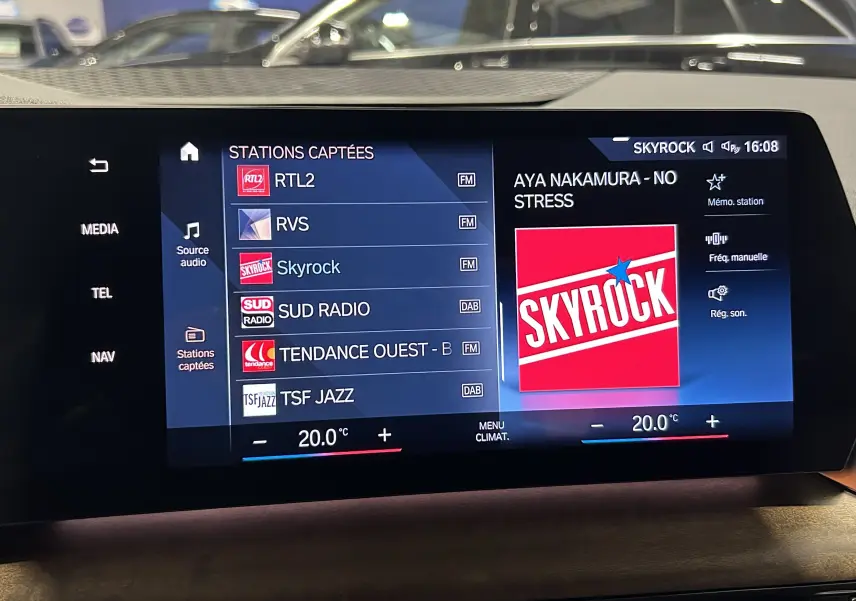 Écran tactile intérieur du système multimédia BMW Série 2 Active Tourer affichant les stations radio et la température à 20°C.