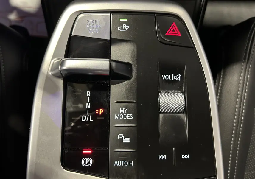 Gros plan sur la console centrale noire et argentée du BMW Série 2 Active Tourer 218i, avec levier de vitesses et commandes multimédia.