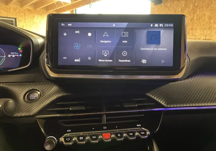 Vue rapprochée du tableau de bord noir du Peugeot 2008 1.2 Hybrid 136 avec écran tactile central et bouton start/stop.