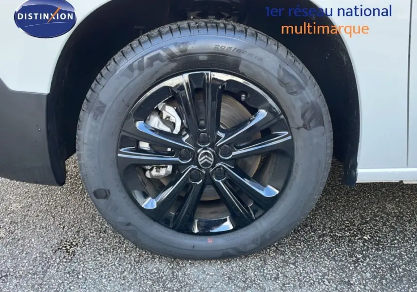 Gros plan sur la roue avant droite noire brillante d’un Citroën Berlingo blanc glacier 2025.