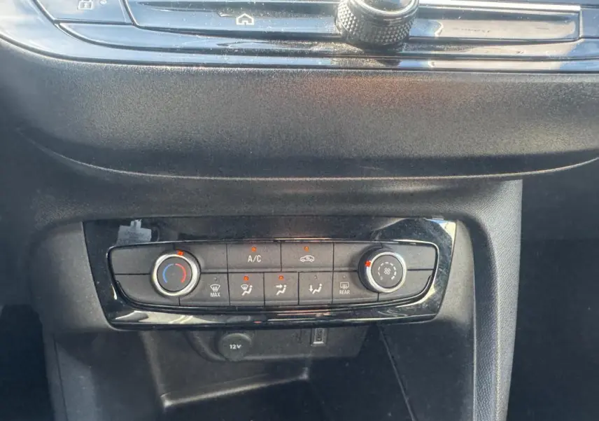 Gros plan sur la console centrale de l’Opel Corsa 2025, montrant les commandes de climatisation et ventilation.