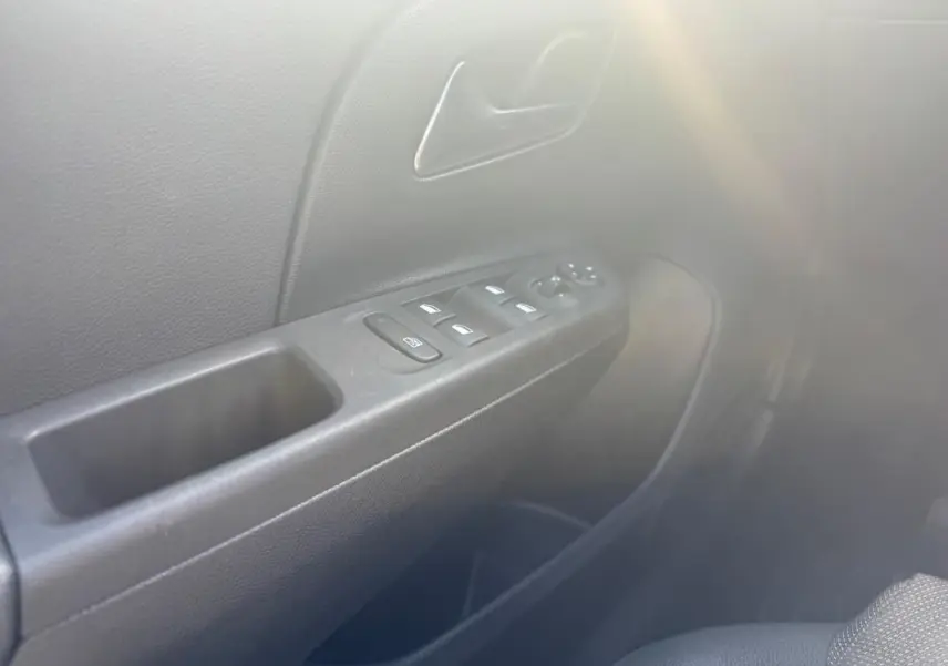 Détail de la porte côté conducteur de l’Opel Corsa 2025 noire, avec commandes des vitres et poignée intérieure visibles.